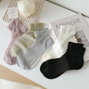 Flat lay of five pairs of ribbed cotton socks with ruffled edges in pastel colors