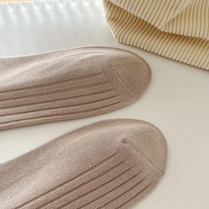 Vue détaillée des chaussettes en coton beige avec une texture en maille côtelée verticale