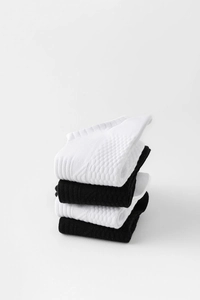 Gros plan sur la texture alvéolée respirante et bords côtes des chaussettes de sport