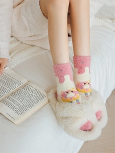 Detail of soft pink mink fleece socks with bear pattern and plush claw slippers in bed