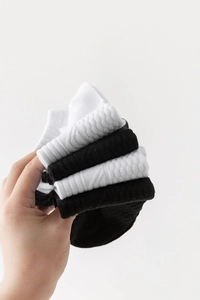 Gros plan sur la texture tricotée de chaussettes de sport en coton noir et blanc