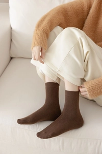 Close-up of deep brown thickened thermal crew socks with soft ribbed cuffs for winter