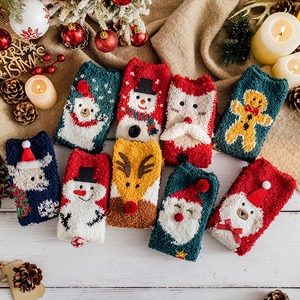 Thick Christmas coral fleece thermal socks featuring festive patterns on a white wooden background
