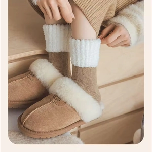Détail de chaussettes en tricot marron chaud avec revers en polaire blanche douce
