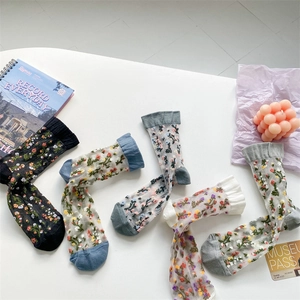 Detailed view of floral pattern glass silk socks in various colors with mesh texture