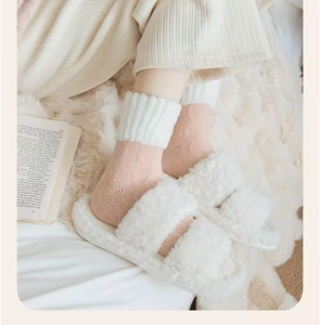 Gros plan sur des chaussettes thermiques roses et pantoufles blanches en peluche