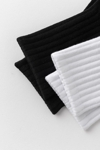Gros plan sur la texture côtelée des chaussettes de sport en coton noir et blanc