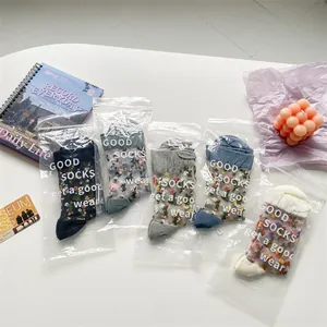 Detailed view of 5-pack floral embroidery mesh socks in individual packaging