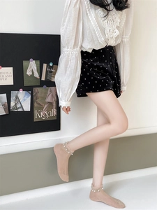 Close-up of light camel mesh socks with pearl beaded cuffs and delicate lace texture