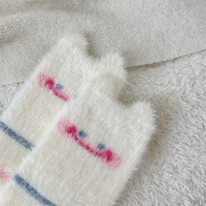 Detailed close-up of soft white mink velvet socks with cute cartoon embroidery