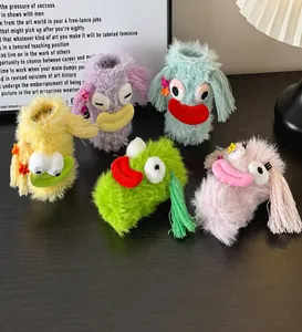 Detailed view of five colorful fuzzy monster socks with 3D eyes on a wooden surface