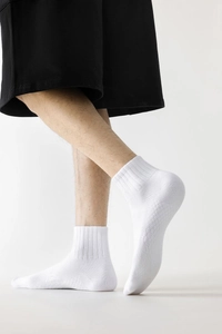 Détail de chaussette de sport blanche avec revers côtelé et maille nid d'abeille