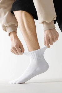 Gros plan sur les chaussettes de sport blanches montrant le bord-côte élastique et le coton