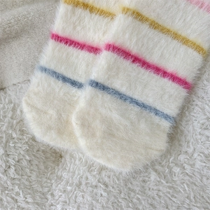 Close-up of soft mink velvet socks with colorful stripes on fuzzy fleece background