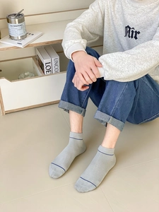 Detail of light gray cotton ankle sock with vertical texture and blue toe stripe