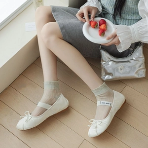 Detail of white Mary Jane ballet flats with soft bow, pearl charm, and buckle strap