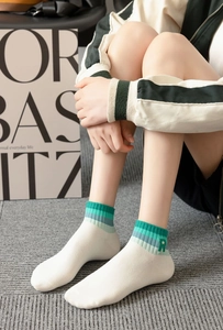 Detail of white cotton ankle socks with rainbow striped cuffs and star embroidery