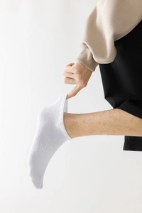 Détail de chaussettes de sport blanches en coton avec bords côtelés et maintien plantaire