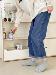 Close-up of light gray low-cut cotton socks featuring a blue stripe on the ankle cuff