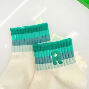 Detailed close-up of ribbed cuffs with green stripes and embroidered letter R on socks
