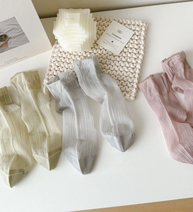 Detail of mesh socks with vertical stripes and elegant wavy ruffled cuffs in pastel colors