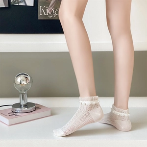 Close-up of beige lace mesh ankle socks with delicate faux pearl trim detail