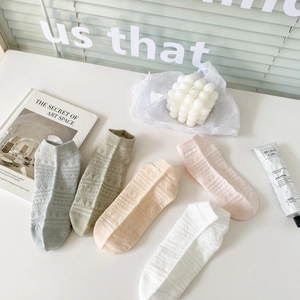 Vue de dessus de cinq paires de chaussettes basses en maille ajourée aux tons pastel