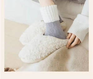Détail de chaussons en peluche blanche et chaussettes en laine pour un confort maison