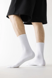 Détail de chaussettes blanches montrant la texture côtelée et le coton sur le pied