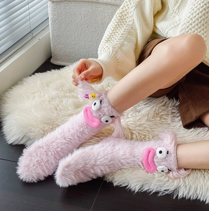 Funny pink fuzzy monster socks with cartoon big eyes and stars for home comfort