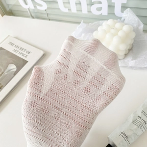 Gros plan de chaussettes en dentelle blanche avec motif losange ajouré et maille respirante