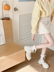 Vue latérale de chaussures Mary Jane à plateforme blanche avec chaussettes en dentelle