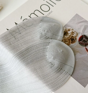 Detail of light gray sheer low-cut socks with breathable pointelle jacquard texture