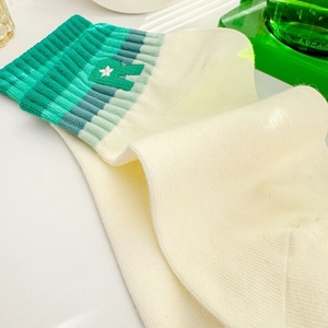 Close-up of R letter embroidery and green ribbed cuffs on cream white cotton socks