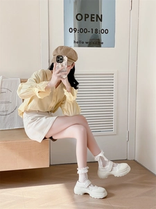 Détail de chaussettes blanches à volants en dentelle avec chaussures Mary Jane beige