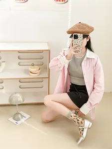Detailed close-up of pink and white color-block shirt collar and button-down front