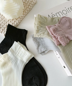 Detailed macro view of soft ribbed texture and diverse pastel colors of cotton ankle socks
