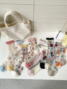 Détail de chaussettes en résille transparente avec broderie florale et bords à volants