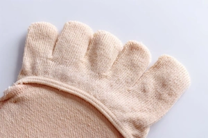 Macro detail of nude five-toe forefoot socks with dense knit texture and flat toe seams