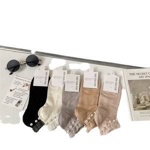 Five pairs of mesh lace socks with pearl trim and ruffled edges in neutral tones
