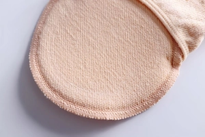 Macro detail of pink forefoot cushion pad showing textured fabric and overlock stitching