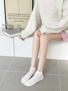 Gros plan de chaussettes blanches en maille pour femmes avec motifs ajourés respirants