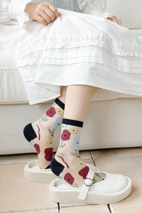 Détail de chaussettes en soie de verre transparentes avec broderies florales colorées