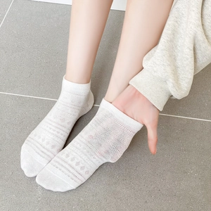 Gros plan détaillé de chaussettes basses blanches en résille avec motifs ajourés respirants