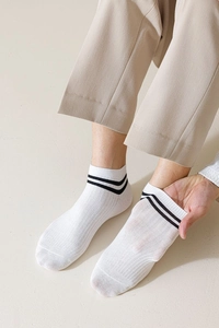 Close-up of white breathable cotton boat socks featuring sporty double black stripes on cuff