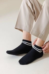 Detail of black cotton ankle socks with white stripes and vertical ribbed texture