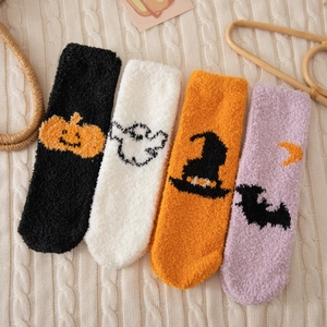 Gros plan de quatre paires de chaussettes d'Halloween épaisses en polaire corail à motifs