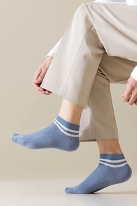 Close-up of light blue low-cut cotton socks with white stripes and ribbed texture