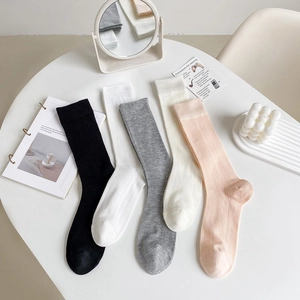 Close-up of 5 pairs of ribbon ballet-style mesh socks in neutral and pastel tones