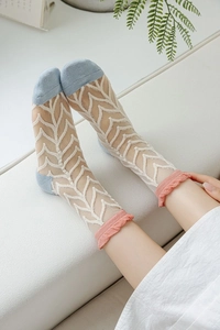 Détail de chaussettes en soie de verre transparentes avec bords volantés roses